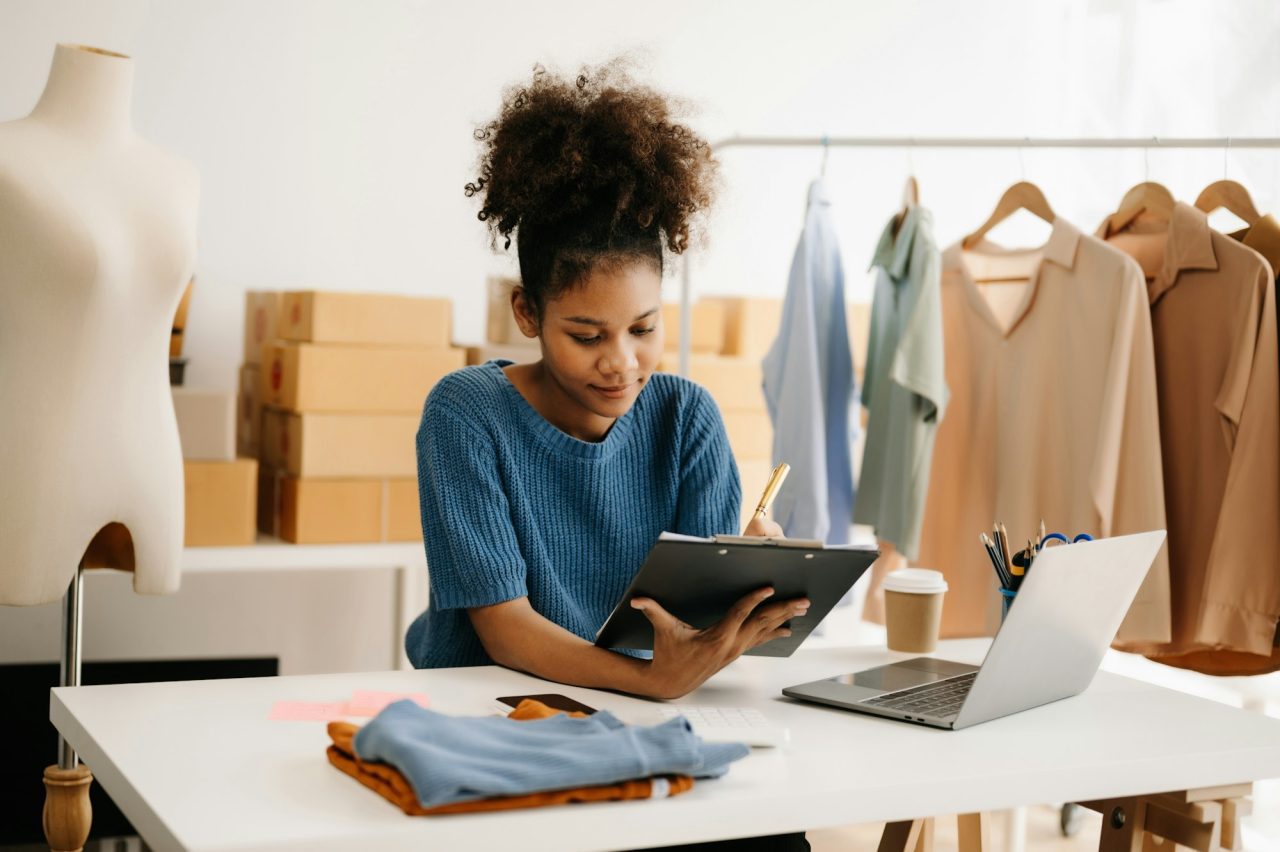 calm-curly-brunette-dark-skinned-woman-on-desk-in-modern-office-of-fashion-designer.jpg